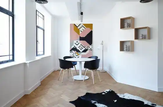 Pièce minimaliste avec table ronde et textile mural